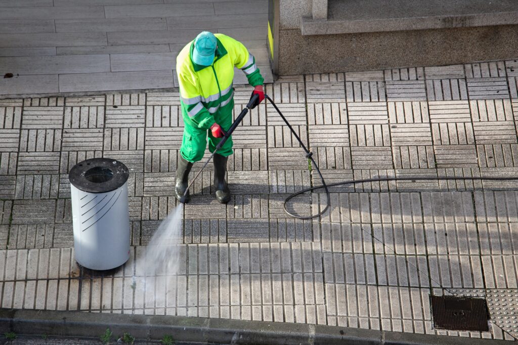 Sweeper cleaning a street sidewalk with high pressure water jet machine